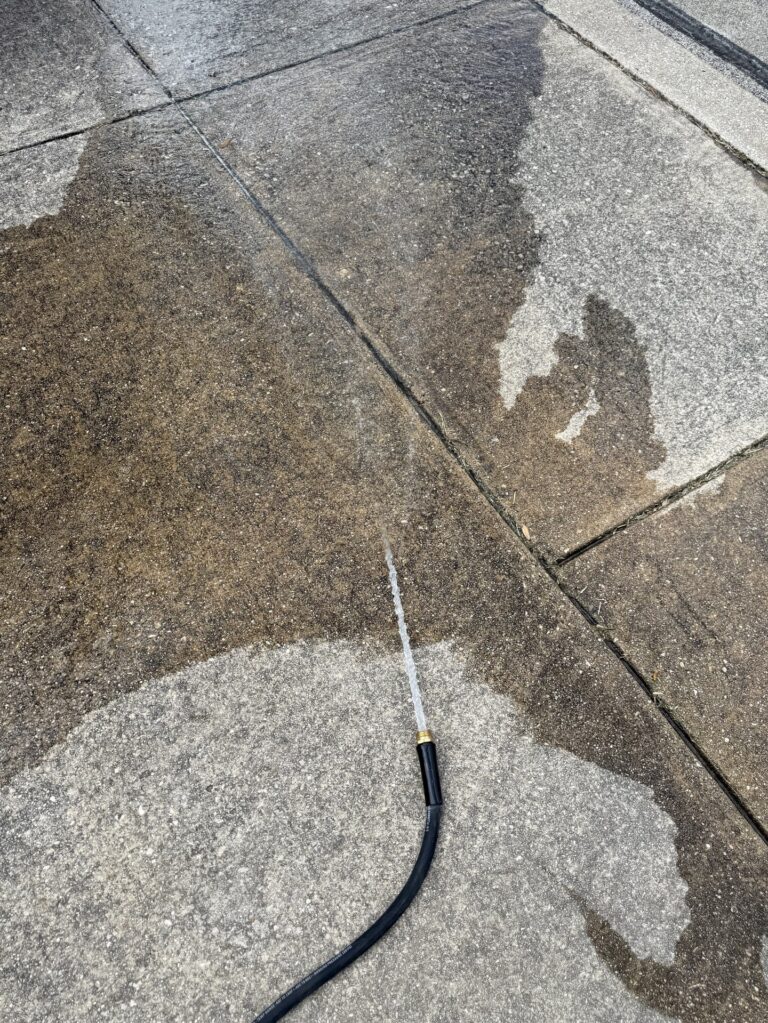 Water heater flush drain hose draining sediment water on concrete Alamo Ranch San Antonio 78254